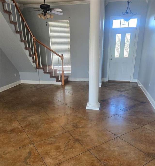 foyer entrance with ornamental molding, ceiling fan, and ornate columns