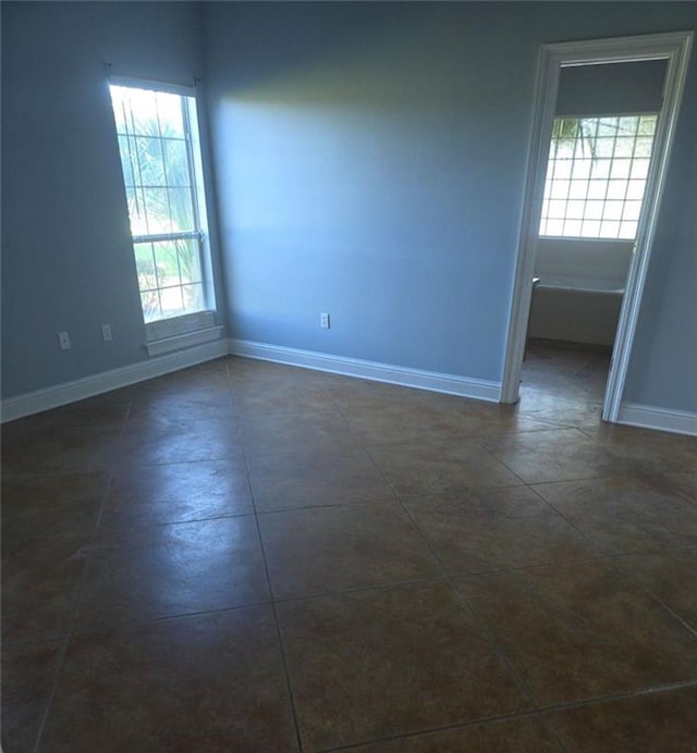 unfurnished room with dark tile patterned floors