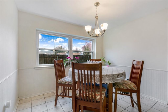 dining area with a chandelier and light tile floors