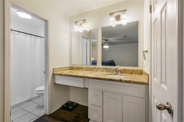 bathroom featuring ceiling fan, tile flooring, toilet, and vanity