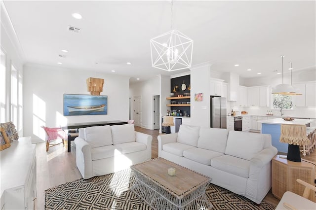 living room with light hardwood / wood-style floors and a notable chandelier