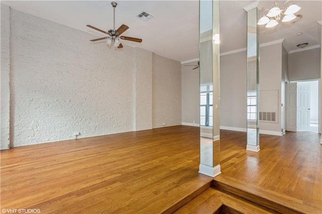 unfurnished room featuring wood-type flooring, ceiling fan with notable chandelier, and ornamental molding