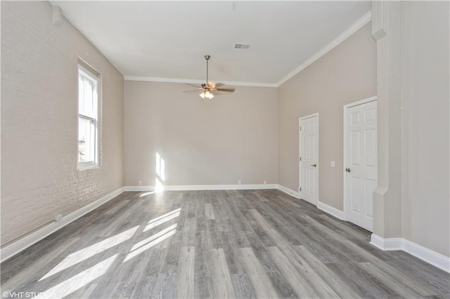 empty room featuring crown molding, dark hardwood / wood-style floors, and ceiling fan