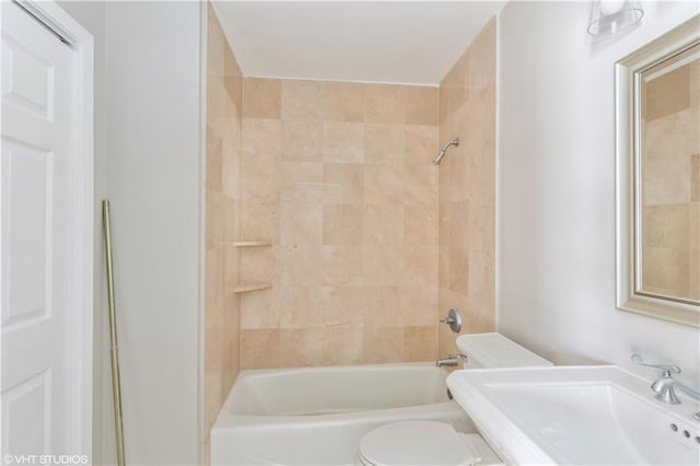 full bathroom with tiled shower / bath combo, toilet, and sink