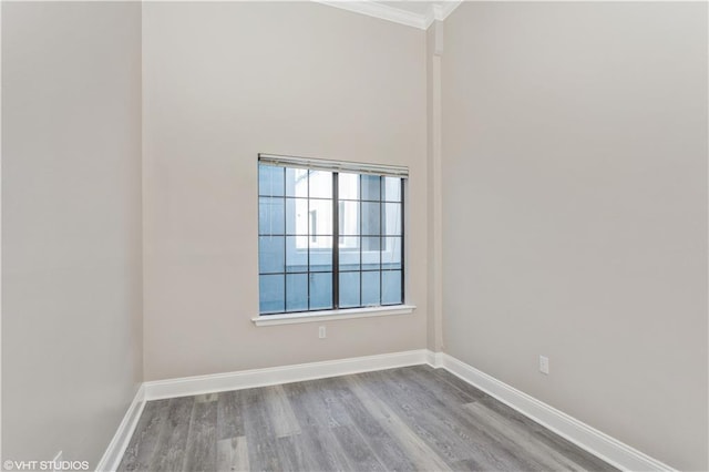 empty room featuring ornamental molding, a healthy amount of sunlight, and light wood-type flooring