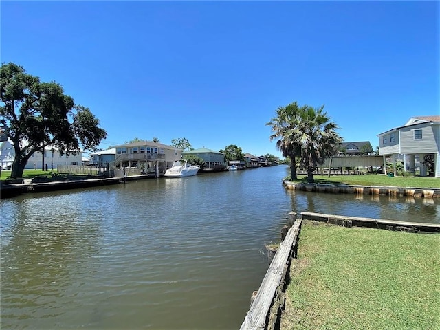 view of dock featuring a lawn and a water view