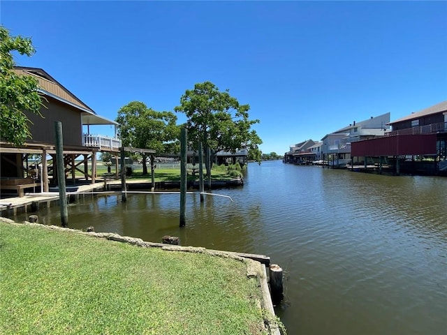 view of dock with a yard and a water view