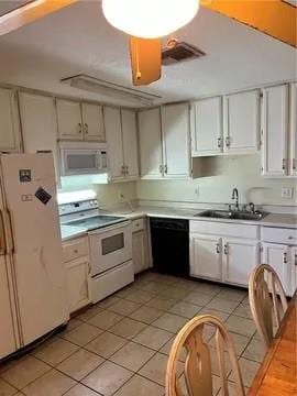 kitchen with white appliances, white cabinetry, sink, and light tile floors