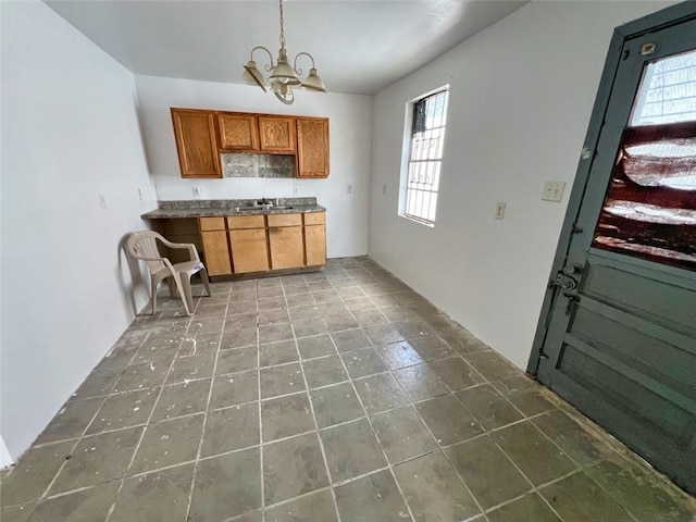 kitchen featuring a chandelier, a healthy amount of sunlight, tile flooring, and sink