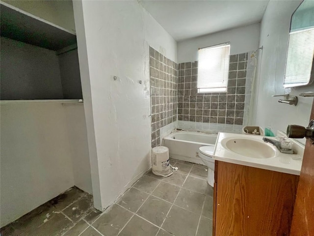 bathroom with toilet, large vanity, and tile floors