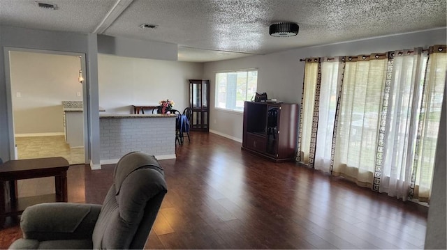 living room with dark wood-type flooring and a textured ceiling