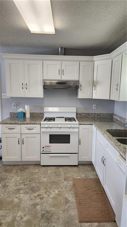 kitchen featuring white cabinetry, a textured ceiling, white appliances, ventilation hood, and light tile floors