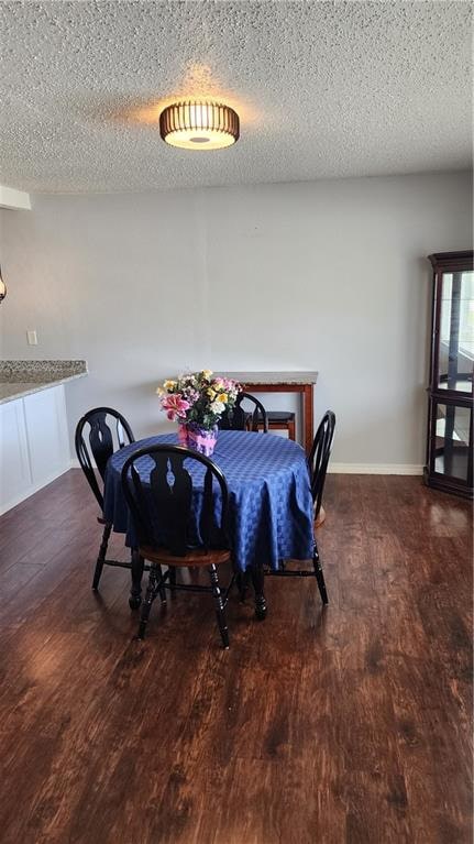 dining space with a textured ceiling and hardwood / wood-style flooring