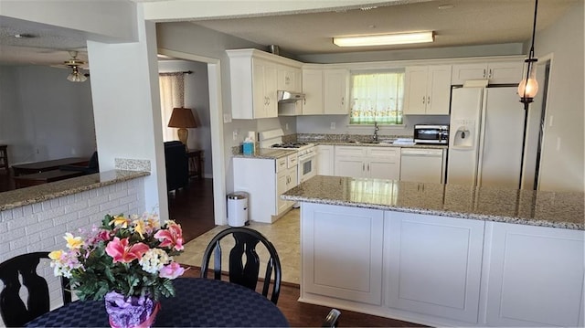 kitchen featuring white cabinets, kitchen peninsula, white appliances, and light wood-type flooring