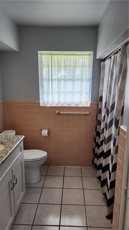 bathroom with tile walls, tile flooring, vanity, and toilet