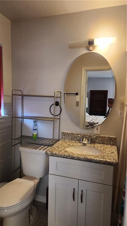 bathroom with tile flooring, vanity, and toilet