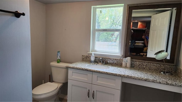 bathroom featuring vanity with extensive cabinet space and toilet