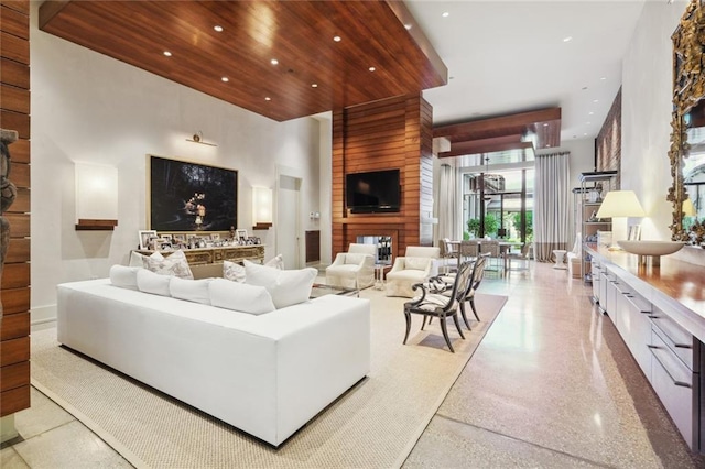 living room with wood walls and a towering ceiling