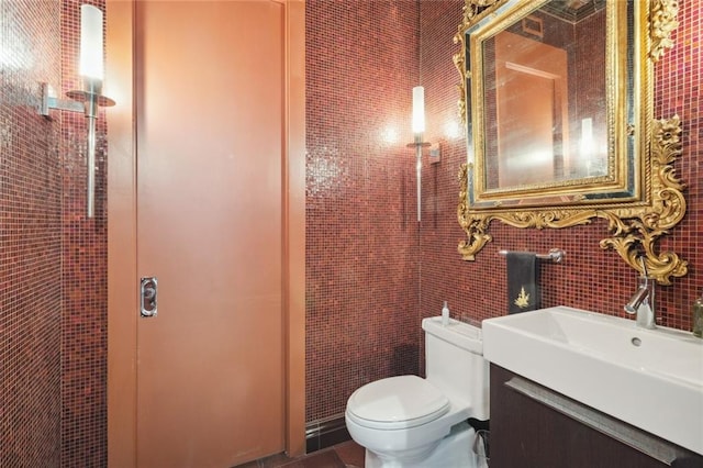 bathroom with tile walls, vanity, and toilet