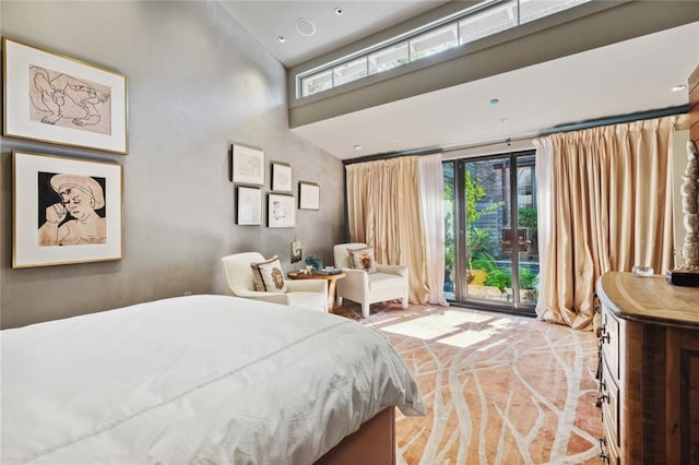 bedroom featuring a towering ceiling and access to outside