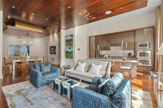 living room featuring wood-type flooring, a notable chandelier, and wooden ceiling