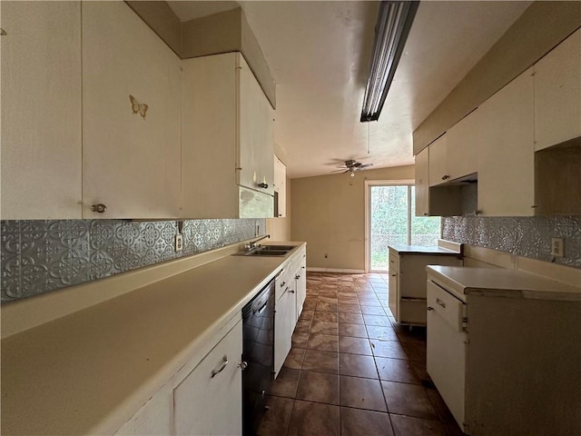 kitchen featuring sink, dark tile flooring, white cabinets, backsplash, and black dishwasher