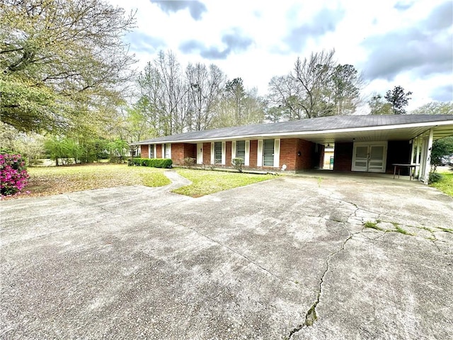 ranch-style home featuring a front lawn and a carport