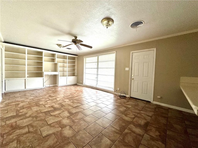 empty room featuring dark tile flooring, crown molding, a textured ceiling, and ceiling fan