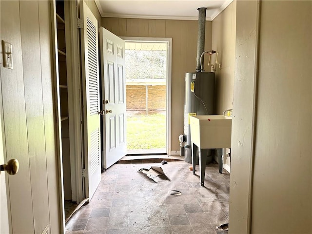 interior space featuring dark tile flooring, water heater, and ornamental molding