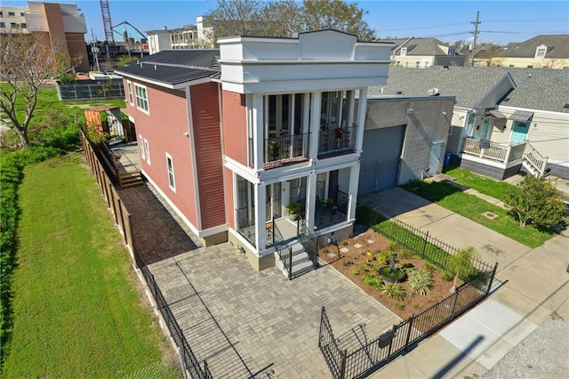 rear view of property featuring a lawn and a balcony