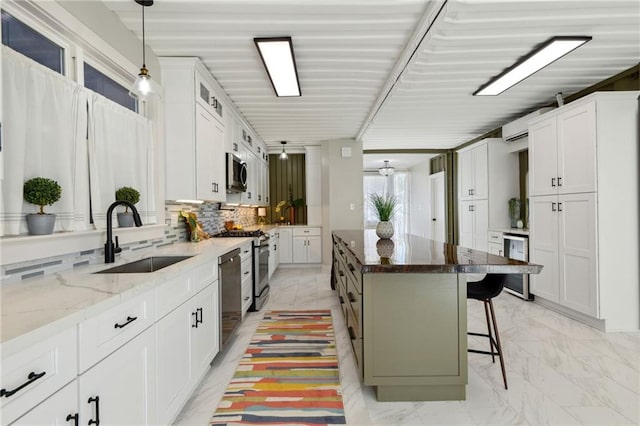 kitchen featuring white cabinetry, a breakfast bar, dark stone countertops, a center island, and tasteful backsplash