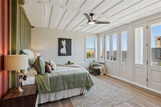 bedroom featuring light hardwood / wood-style flooring, ceiling fan, and multiple windows