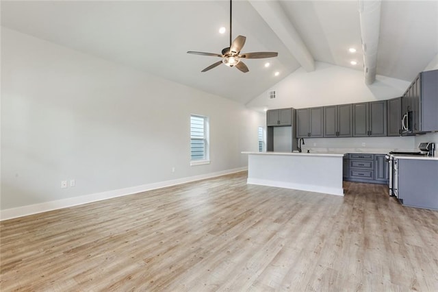 kitchen with beamed ceiling, light hardwood / wood-style floors, ceiling fan, and range