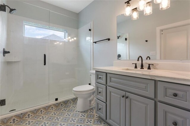 bathroom with tile flooring, vanity with extensive cabinet space, an enclosed shower, and toilet