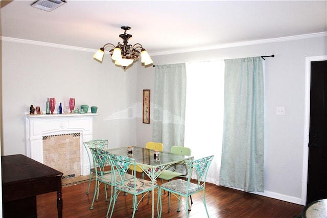 dining room with ornamental molding, dark hardwood / wood-style floors, and an inviting chandelier