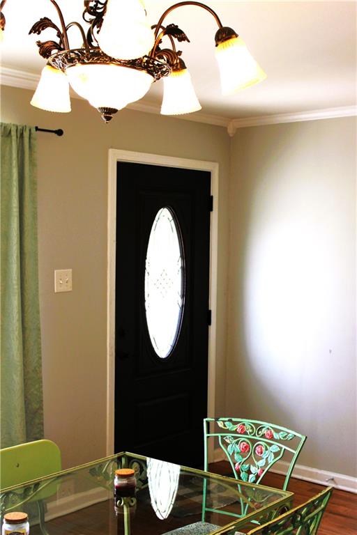 foyer featuring wood-type flooring and crown molding