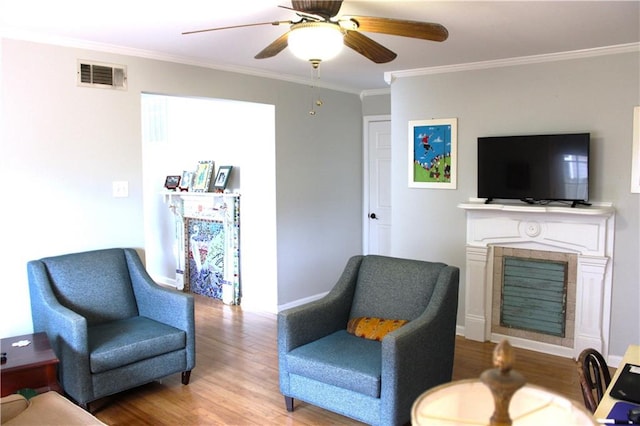 living area featuring ornamental molding, light hardwood / wood-style floors, and ceiling fan