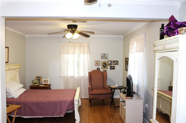 bedroom featuring ceiling fan, ornamental molding, and light hardwood / wood-style flooring