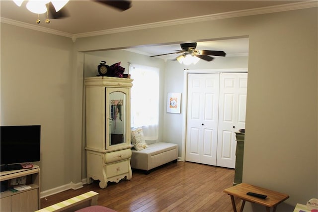 interior space with ornamental molding, hardwood / wood-style floors, ceiling fan, and a closet