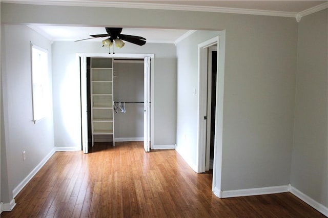 unfurnished bedroom featuring a closet, wood-type flooring, ceiling fan, and crown molding