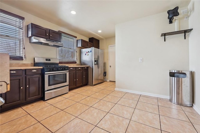 kitchen featuring dark brown cabinets, appliances with stainless steel finishes, and light tile patterned floors