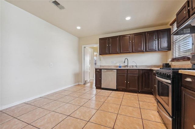 kitchen with light tile patterned flooring, stainless steel appliances, a sink, visible vents, and light countertops