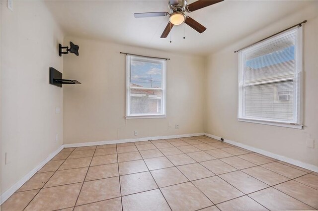 tiled spare room with ceiling fan