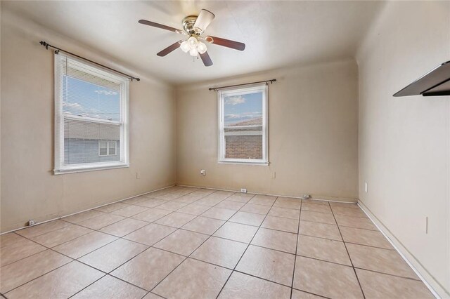 tiled spare room with ceiling fan