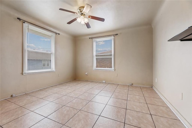 spare room with ceiling fan and light tile patterned floors