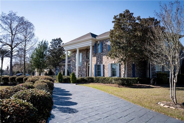 greek revival house featuring a front yard