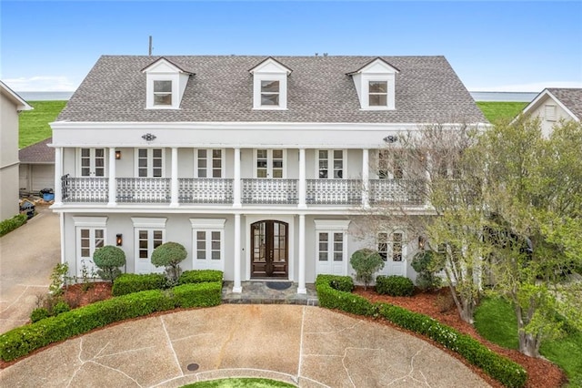 view of front facade with a balcony and french doors