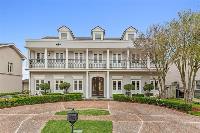 view of front of home featuring a balcony and french doors