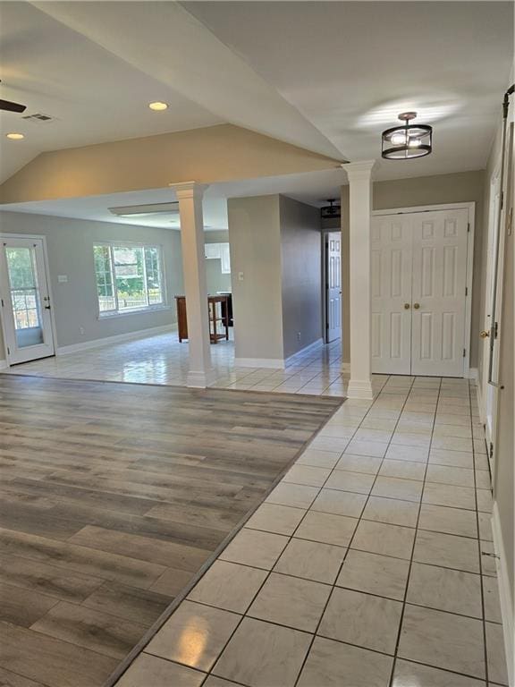 foyer entrance featuring ceiling fan, lofted ceiling, light wood-type flooring, and ornate columns