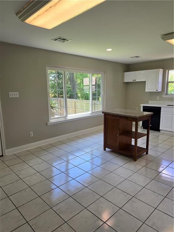 kitchen featuring light tile patterned floors, dishwasher, and white cabinets